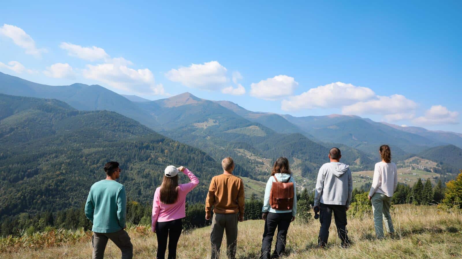 Grupo de personas contemplando un valle de montaña