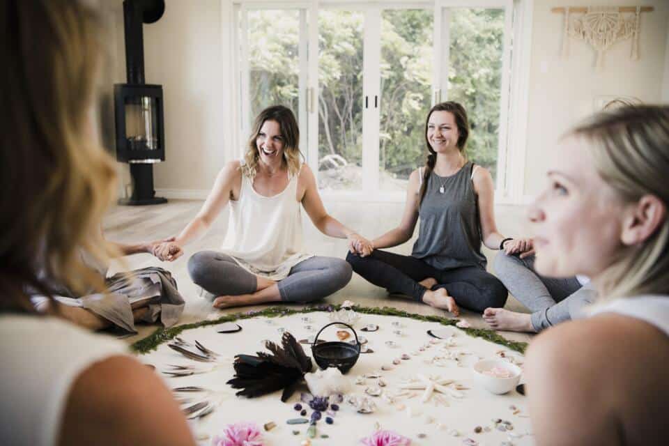 Círculo de mujeres practicando mindfulness sentadas en el suelo de una sala luminosa